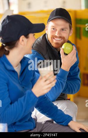 construction workers having a break and eating apple Stock Photo