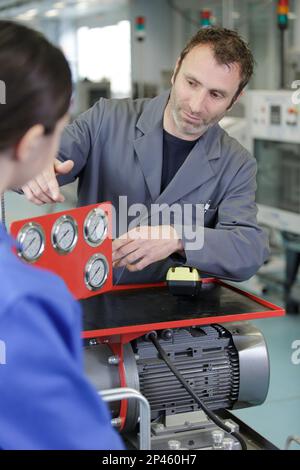 apprentice car mechanics working on an engine Stock Photo