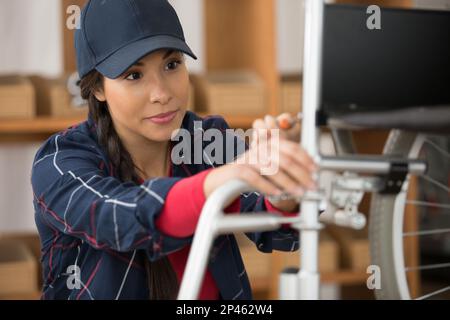 female worker is fixing a wheelchair Stock Photo - Alamy