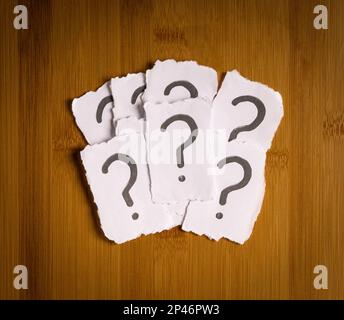 Heap of white papers with question mark. Top view. Confusion or indecision concept. Stock Photo