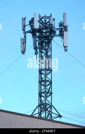 Closeup of a cell phone tower on the roof of a building against a blue sky, Vancouver, BC, Canada Stock Photo