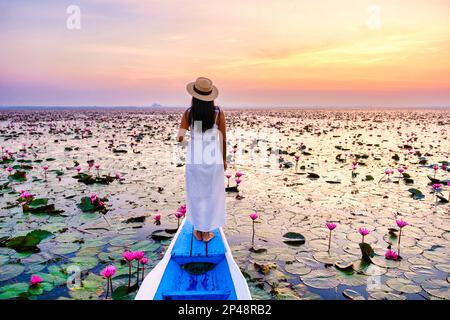 Asian women in a boat at the Beautiful Red Lotus Sea in Udon Thani in northern Thailand. Flora of Southeast Asia. Stock Photo