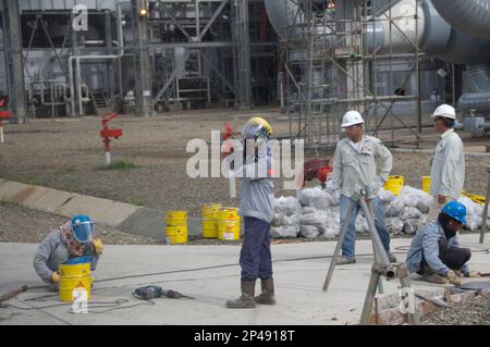 Workmen fixing road, Pipework and vessels, Tangguh LNG (Liquified Natural Gas) Plant. near Babo, West Papus, Indonesia Stock Photo