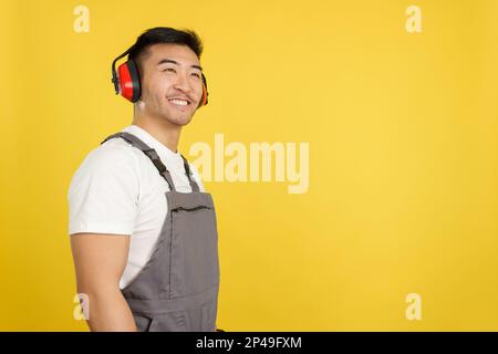 Chinese carpenter smiling distracted while looking up Stock Photo