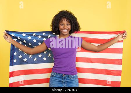 Happy woman with afro hair raising a USA flag Stock Photo