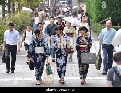 Men wearing yukata head to work in Shibuya Ward, Tokyo on July 30, 2014. As  part of a  Shibuya Summer Festival event to promote traditional Japanese  culture among young people and