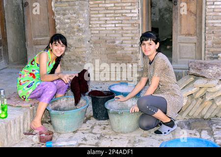 Uzbek women working in a small rug family owned factory in the old city of Bukhara, Uzbekistan. Stock Photo