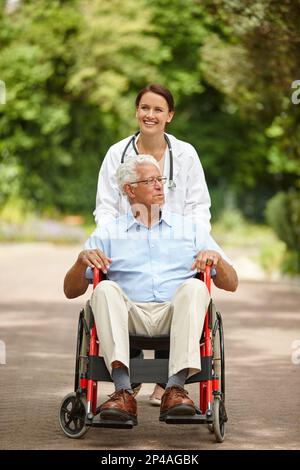 Nice day to be out and about. a female doctor taking her senior patient for an outing in his wheelchair. Stock Photo