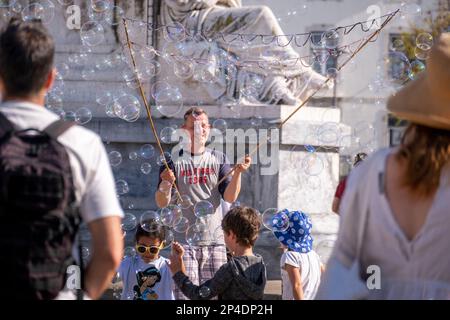 Children playing with bubbles in a park in Lisbon, Portugal Stock Photo