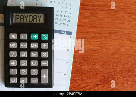 Top view image of calendar and calculator with text PAYDAY. Finance concept Stock Photo