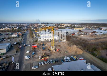 a large yellow construction crane and various construction machines are used on a construction site Stock Photo