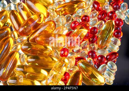 Close up pile of golden capsules of vitamin D3. Biologically active substances. Stock Photo