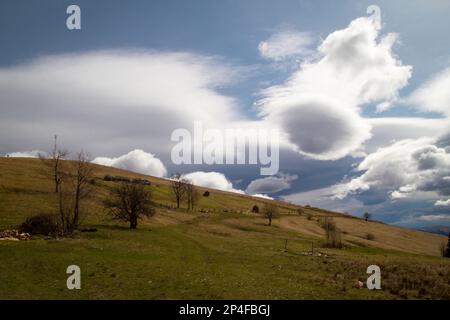 Old farm on steep slope landscape photo. Nature scenery photography with soft puffy clouds on background. Ambient light. High quality picture for wall Stock Photo