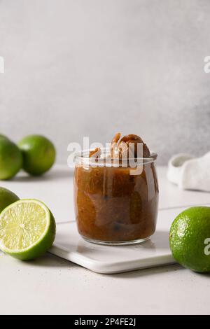 Popular Sri Lankan Lime Pickle of lime, salt, chilli, pepperon white background. Vertical format. Stock Photo