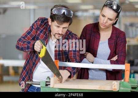 two carpenters are sawing wood Stock Photo