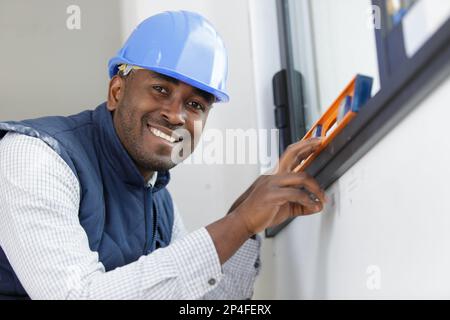 happy construction worker using bubble level Stock Photo