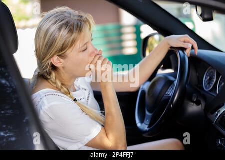 young tired woman in driver seat Stock Photo