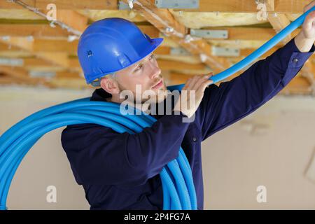 builder installing blue pvc pipe Stock Photo