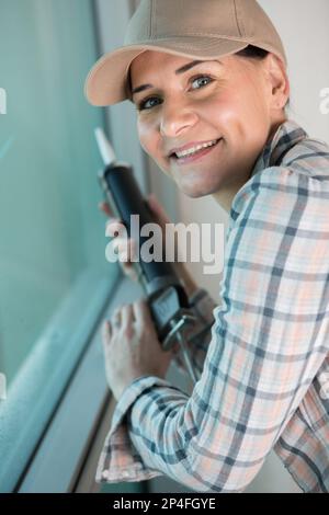 female builder installing window in a building Stock Photo