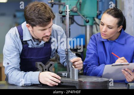 engineer training apprentices on cnc machine Stock Photo