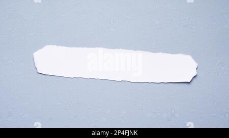 blank torn strip of paper with copy space on blue desk pad, 16:9 format header Stock Photo