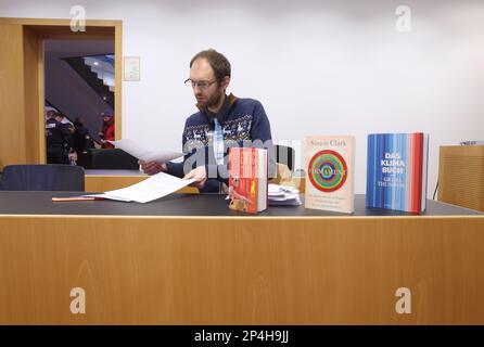 Augsburg, Germany. 06th Mar, 2023. A 34-year-old man sits in the dock at the district court, behind books dealing with climate change. The man is accused of having occupied the government of Swabia with two other people in October 2022 despite a house ban and of having accused the then government president of corruption. Credit: Karl-Josef Hildenbrand/dpa/Alamy Live News Stock Photo