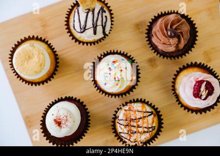 birthday cupcake assortment on wood cutting board Stock Photo