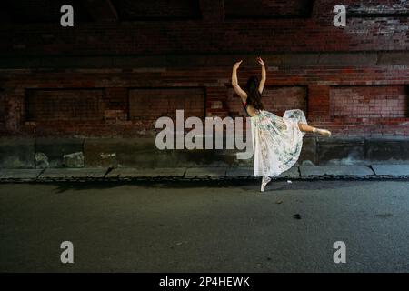 ballerina dancing under bridge outside Stock Photo