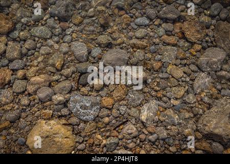 Water and rocky shapes on the beach. Stock Photo