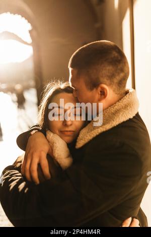 man and a woman are kissing and embracing in  rays of autumn sun Stock Photo