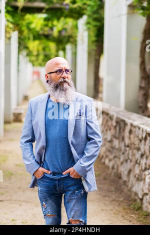 man posing standing with his hands in his pockets in a city park. Stock Photo