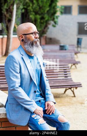 bearded man sitting in a park relaxing Stock Photo