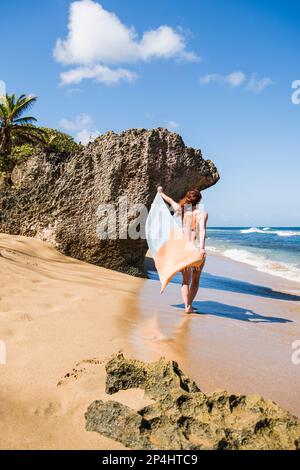 Solo Woman in a bikini with towel at the beach in Puerto Rico Stock Photo