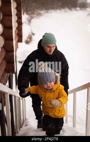 Dad and son climd stairs in winter outdoor Stock Photo