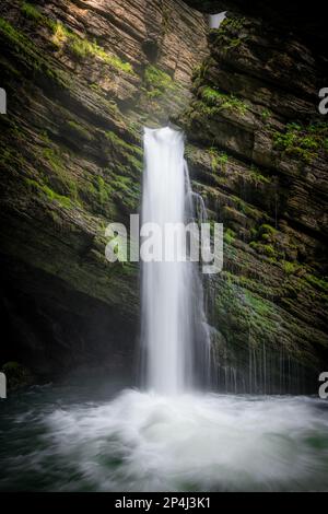 A mystical waterfall surrounded by moss Stock Photo