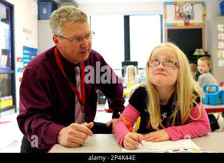 Coon Rapids-Bayard superintendent Rich Stoffers, left, challenges  kindergarten student Kally Wiskus during a writing exercise in a visit to a  classroom taught by Nicole Meyers on Tuesday, March 25, 2014, in Coon  Rapids, Iowa. Stoffers has announced that
