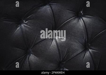 Tufted black material cushion abstract pattern background with buttons Stock Photo