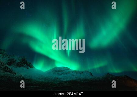 Northern lights over the snowy mountains, frozen sea, reflection in ...