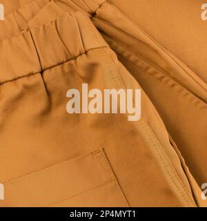 Detail of pants in ocher color belt and part of the pockets close up Stock Photo