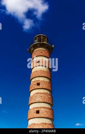 Lisbon Belem red brick waterfront lighthouse against blue sky, before Monument of the Discoveries, Padrao dos Descobrimentos. Stock Photo