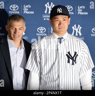 New York Yankees Manager Joe Girardi shakes hands with Masahiro Tanaka who  is wearing his new Yankees jersey and cap at a press conference at Yankee  Stadium in New York City on