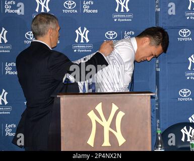 New York Yankees Manager Joe Girardi shakes hands with Masahiro Tanaka who  is wearing his new Yankees jersey and cap at a press conference at Yankee  Stadium in New York City on