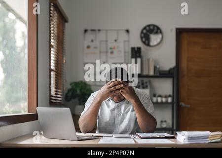 Tired depressed african businessman frustrated by business failure bankruptcy looking at laptop feel exhausted having headache, upset stressed black Stock Photo