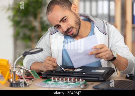 it technician repairing broken laptop notebook computer Stock Photo