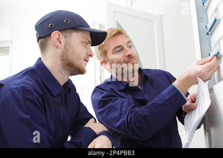two technicians read a plan in the workshop Stock Photo