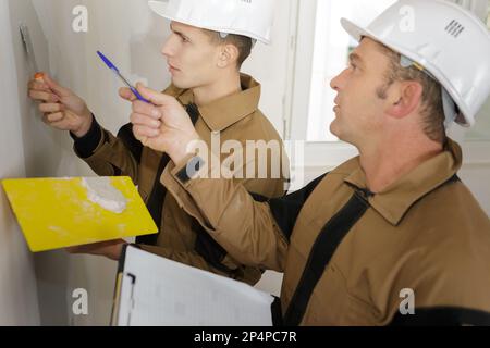 happy builder in hardhat plastering a wall Stock Photo