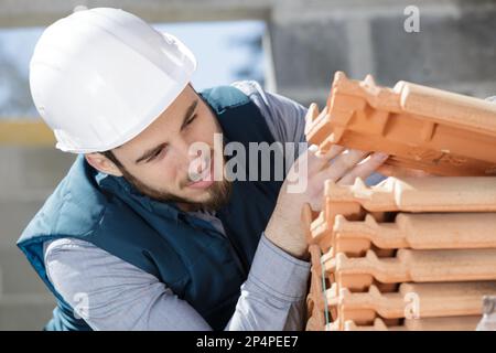 builder working on roof tiles Stock Photo