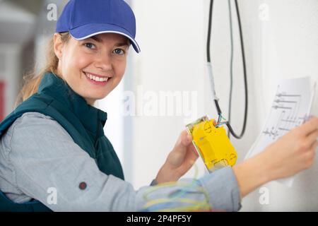 female electrician is smiling at the camera Stock Photo