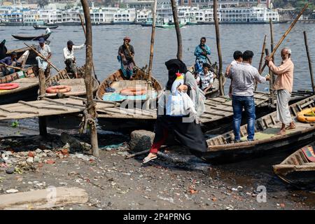 Dhaka, Bangladesh. 06th Mar, 2023. Boatmen wait for passengers to cross the polluted Buriganga river in Dhaka. The pollution of the Buriganga river has become serious due to the liquid waste discharged from the textile industries. The natural color of the water has been lost. Credit: SOPA Images Limited/Alamy Live News Stock Photo