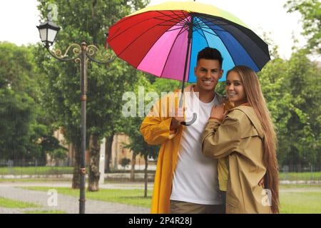 Lovely couple with umbrella walking under rain in park Stock Photo - Alamy